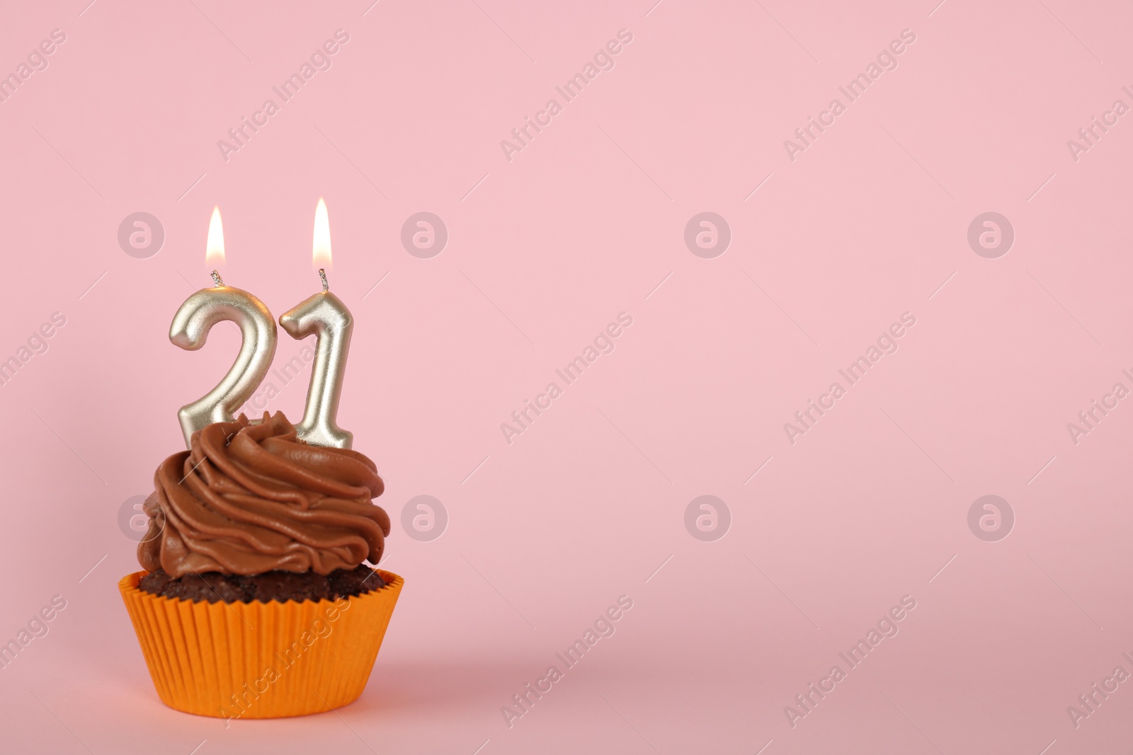 Photo of Delicious cupcake with number shaped candles on pink background, space for text. Coming of age party - 21th birthday