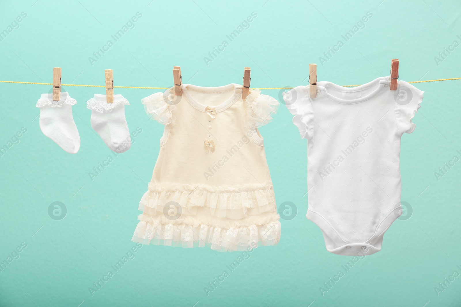 Photo of Children's clothes on laundry line against color background