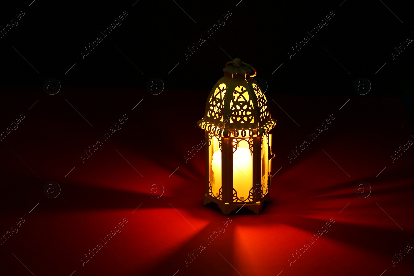 Photo of Decorative Arabic lantern on table against dark background. Space for text