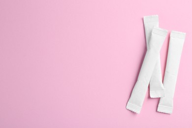 Photo of White sticks of sugar on pink background, flat lay. Space for text