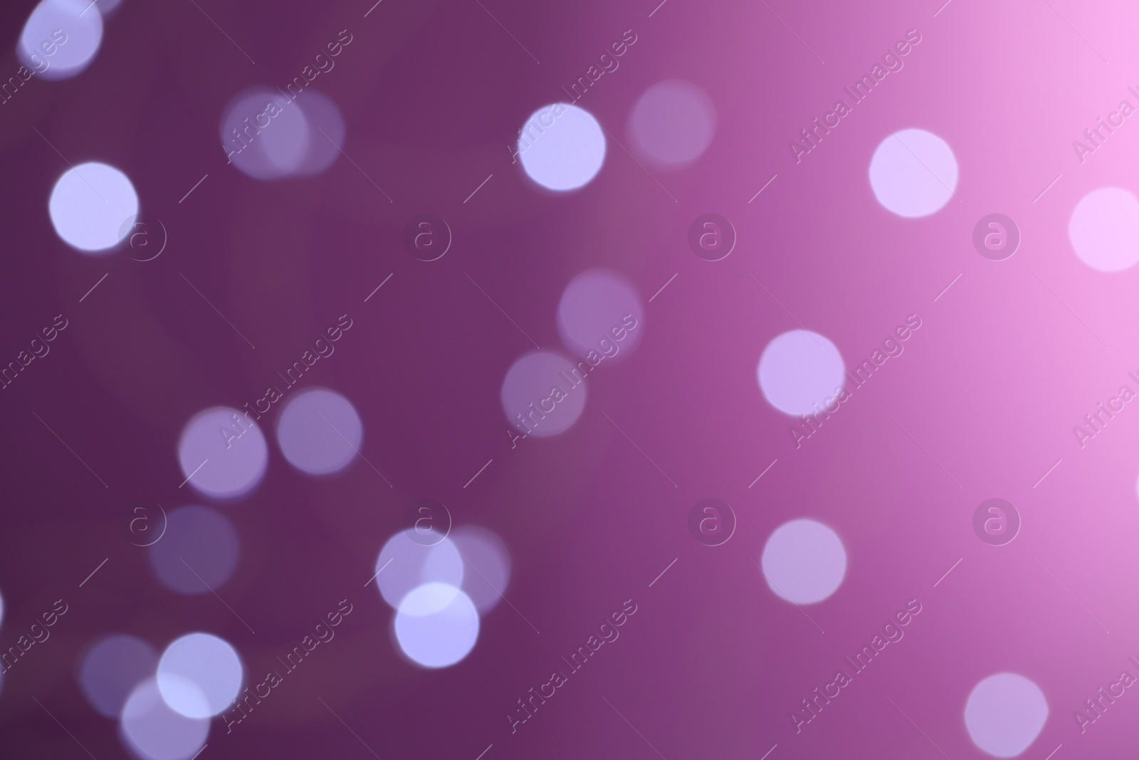Photo of Blurred view of festive lights on purple background. Bokeh effect