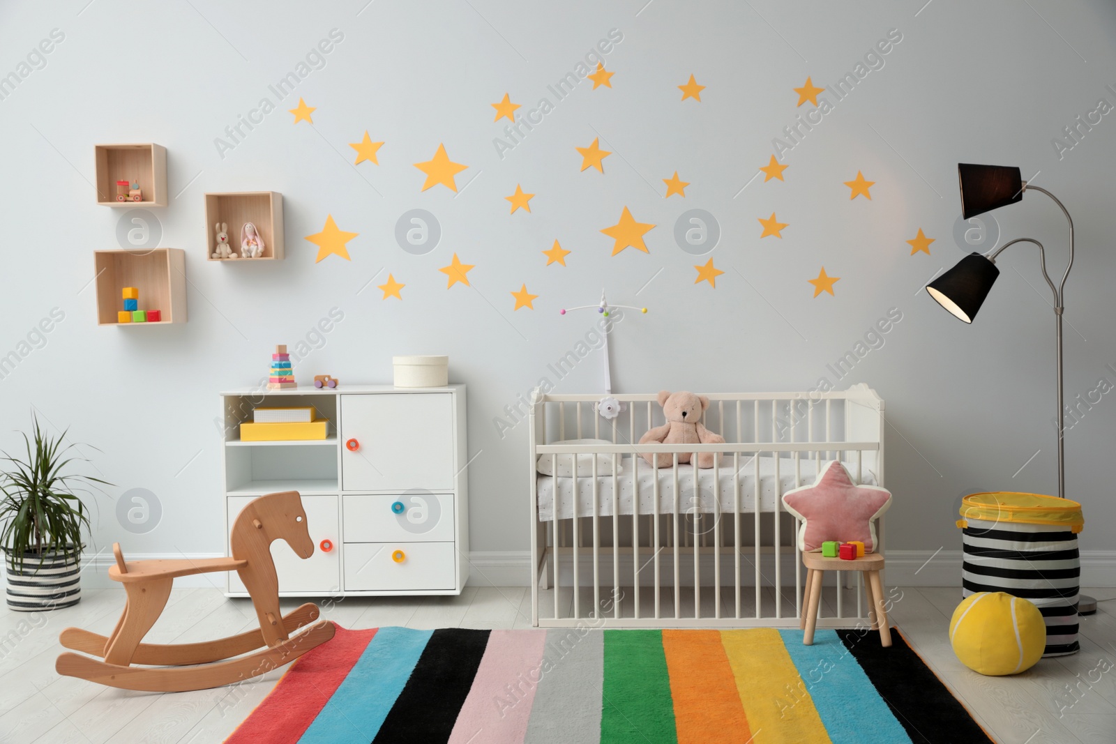 Photo of Stylish baby room interior with crib and toys