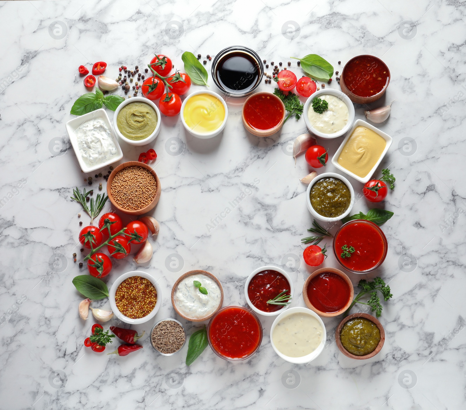 Photo of Frame made with different sauces and ingredients on marble background, flat lay. Space for text