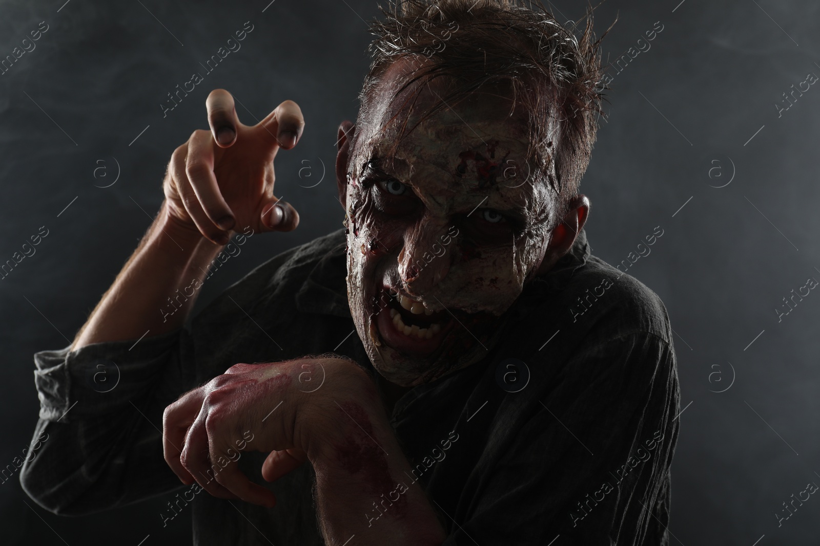 Photo of Scary zombie on dark background. Halloween monster