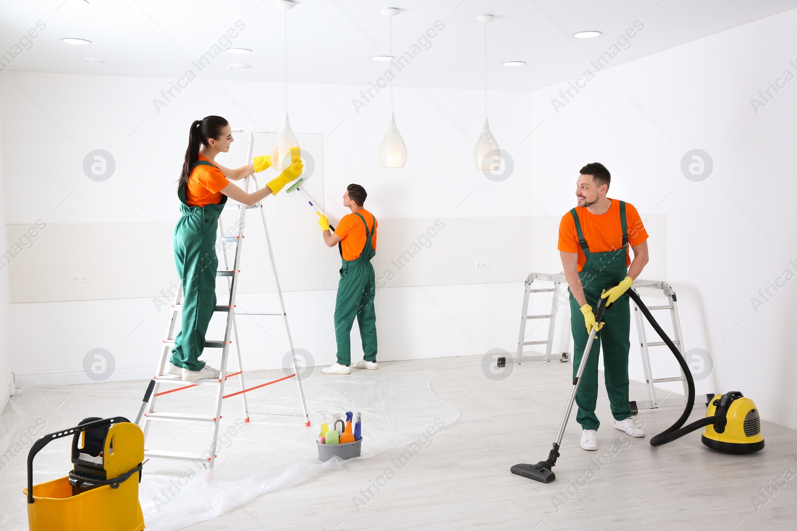 Photo of Team of professional janitors cleaning room after renovation