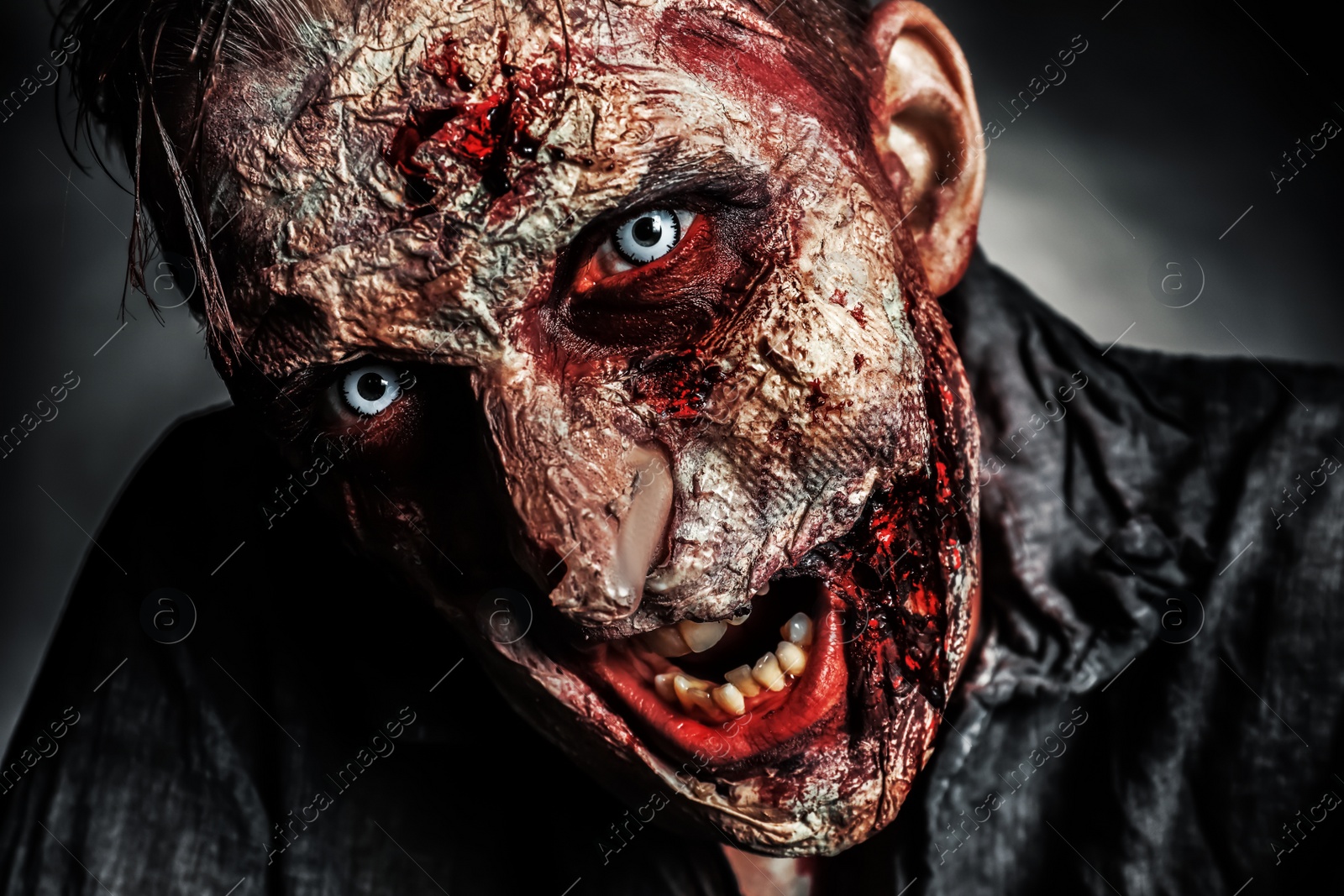 Photo of Scary zombie on dark background, closeup. Halloween monster