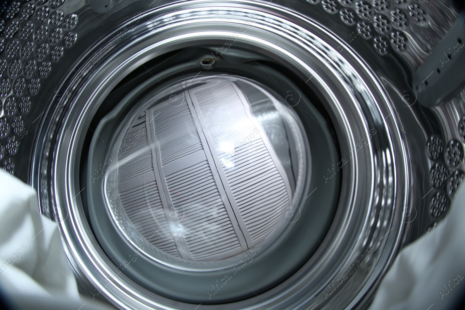 Photo of Clothes in washing machine indoors, view from inside. Laundry day