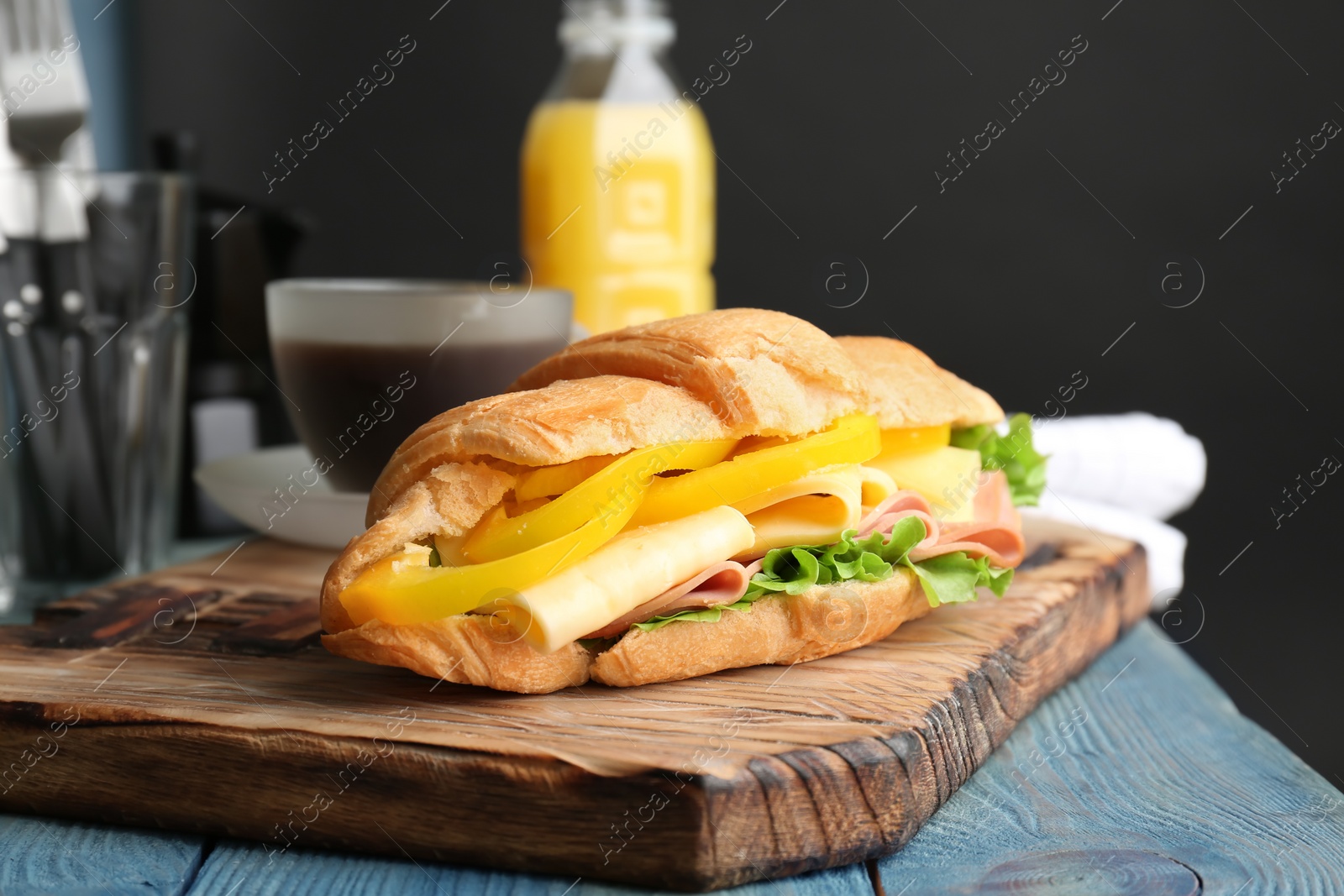 Photo of Tasty croissant sandwich with sausage on table