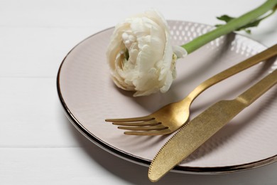 Photo of Stylish table setting with cutlery and flower on white wooden background, closeup