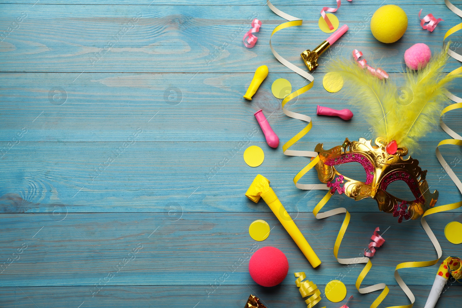 Photo of Flat lay composition with carnival items on light blue wooden background. Space for text