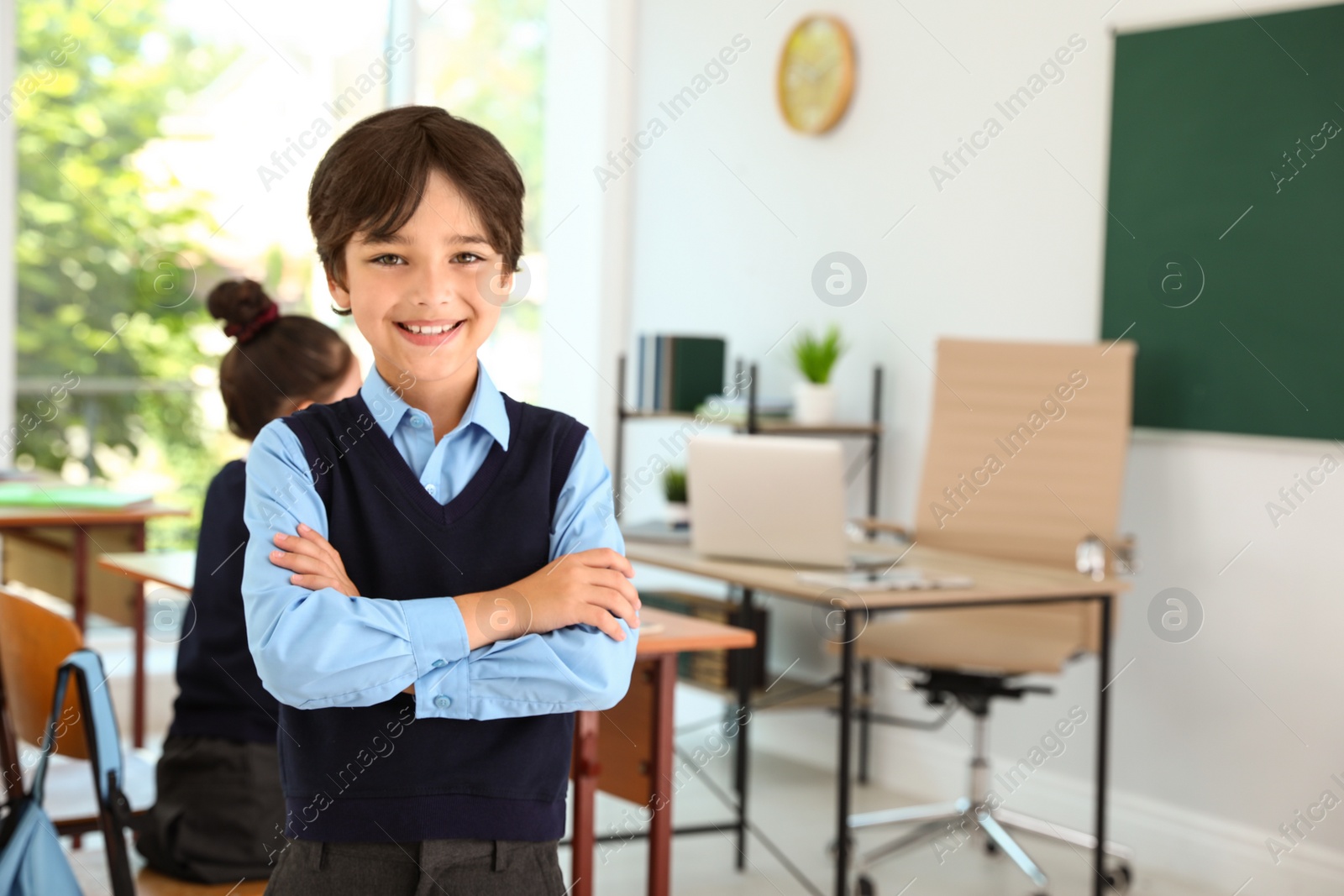 Photo of Boy wearing new school uniform in classroom