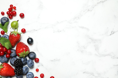 Photo of Mix of fresh berries on white marble table, flat lay. Space for text