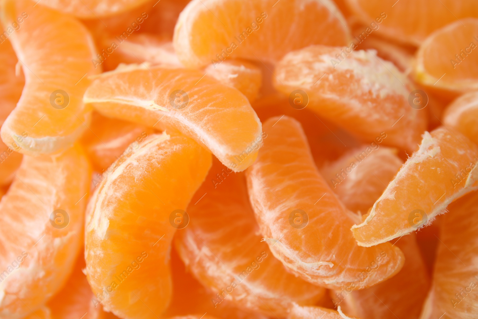 Photo of Segments of tasty tangerines as background, closeup