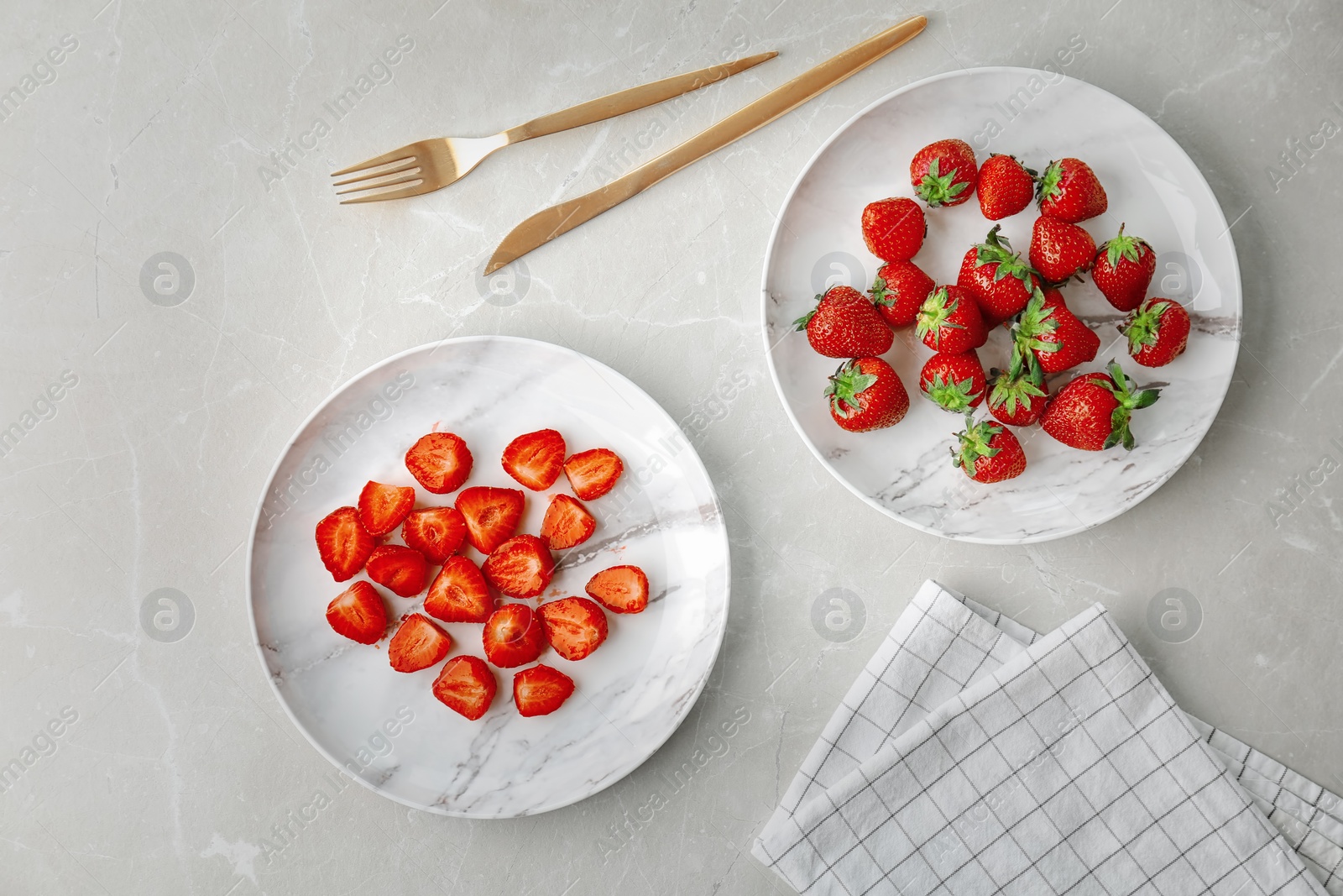 Photo of Plates with ripe red strawberries on light background, top view