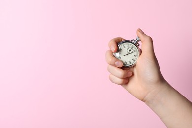 Woman holding vintage timer on pink background, closeup. Space for text