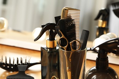 Photo of Set of hairdresser tools on table in salon, closeup