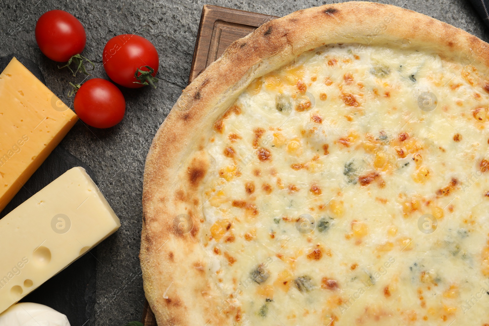 Photo of Delicious cheese pizza and ingredients on dark grey table, flat lay