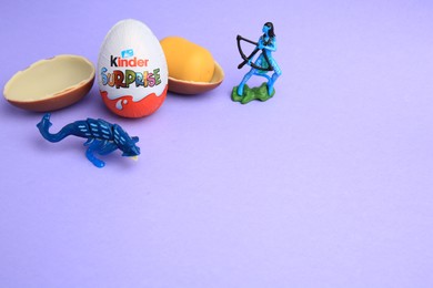Sveti Vlas, Bulgaria - June 30, 2023: Kinder Surprise Eggs, plastic capsule and toys on violet background, space for text