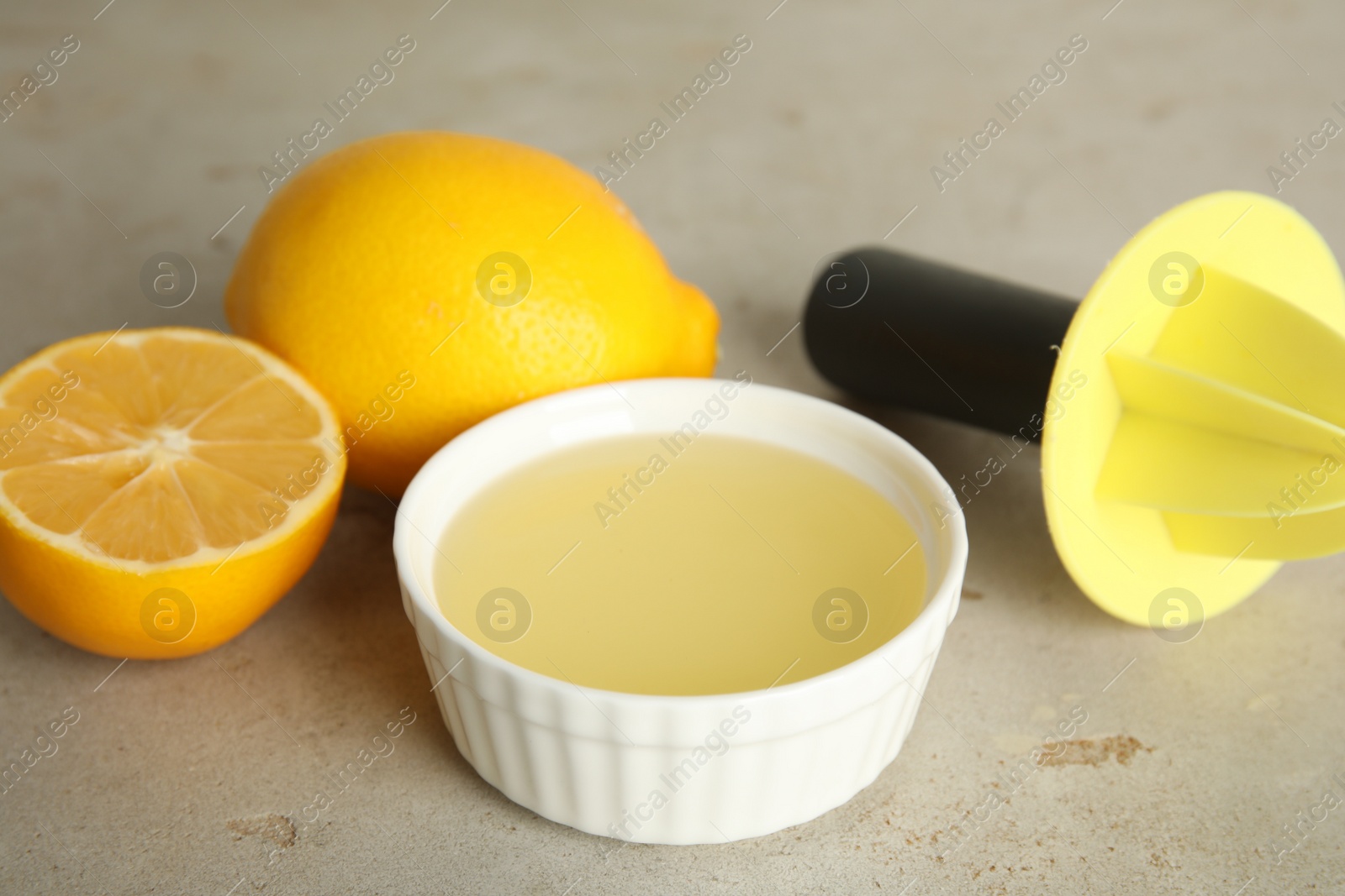 Photo of Freshly squeezed lemon juice on light grey table