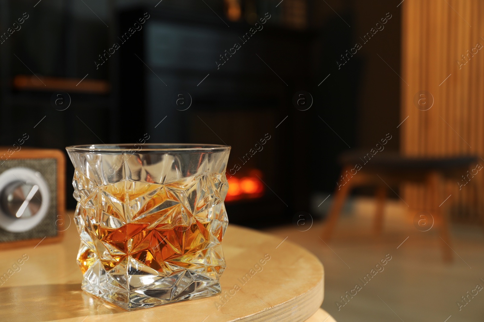 Photo of Glass of whiskey on table in room, space for text. Relax at home
