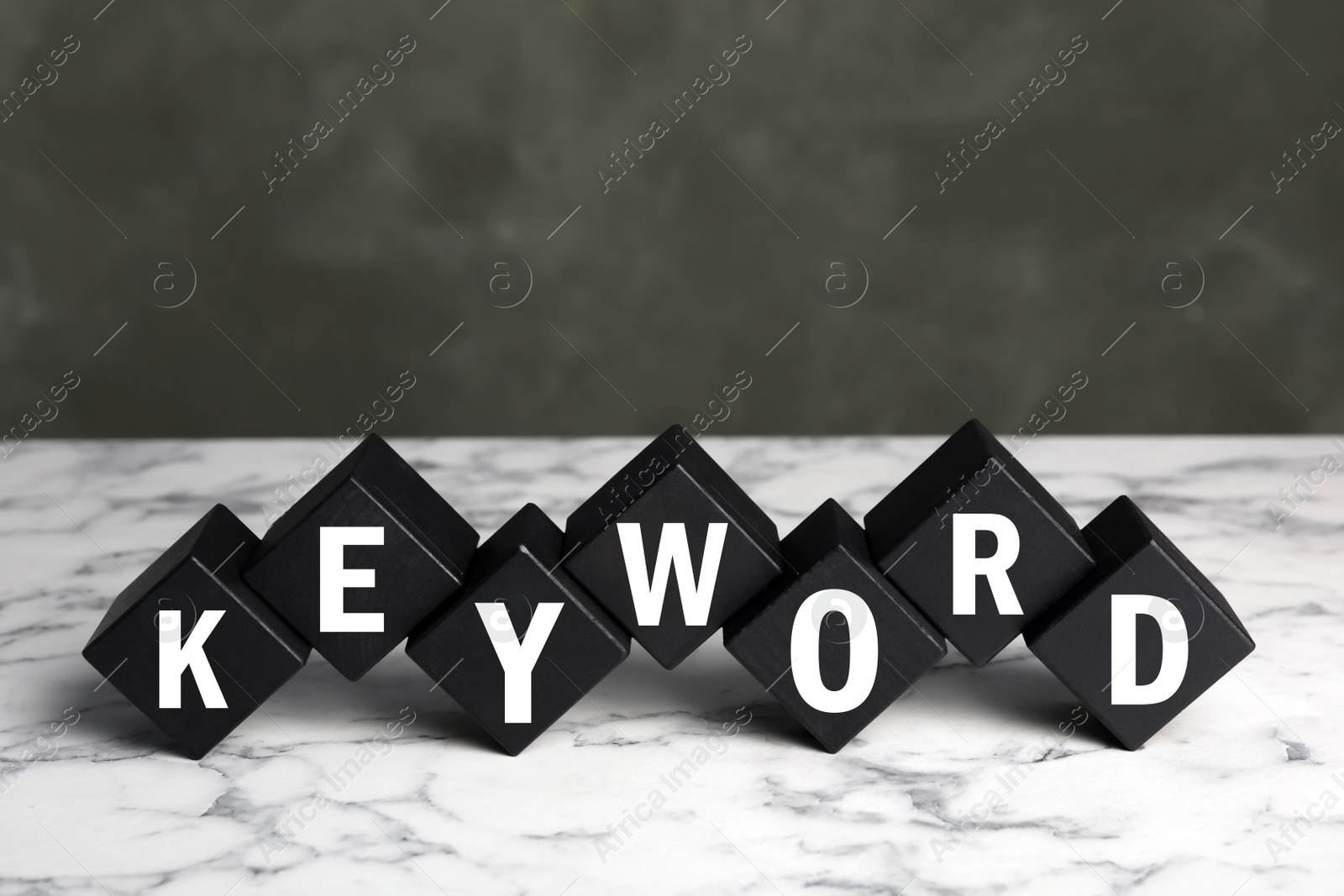 Photo of Black cubes with word KEYWORD on white marble table
