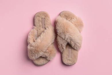 Photo of Pair of soft fluffy slippers on pink background, top view
