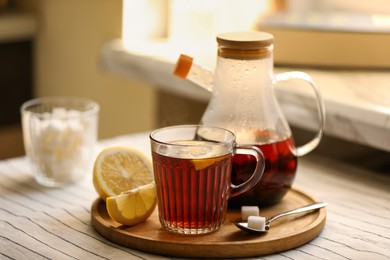 Photo of Aromatic tea with lemon and sugar on table