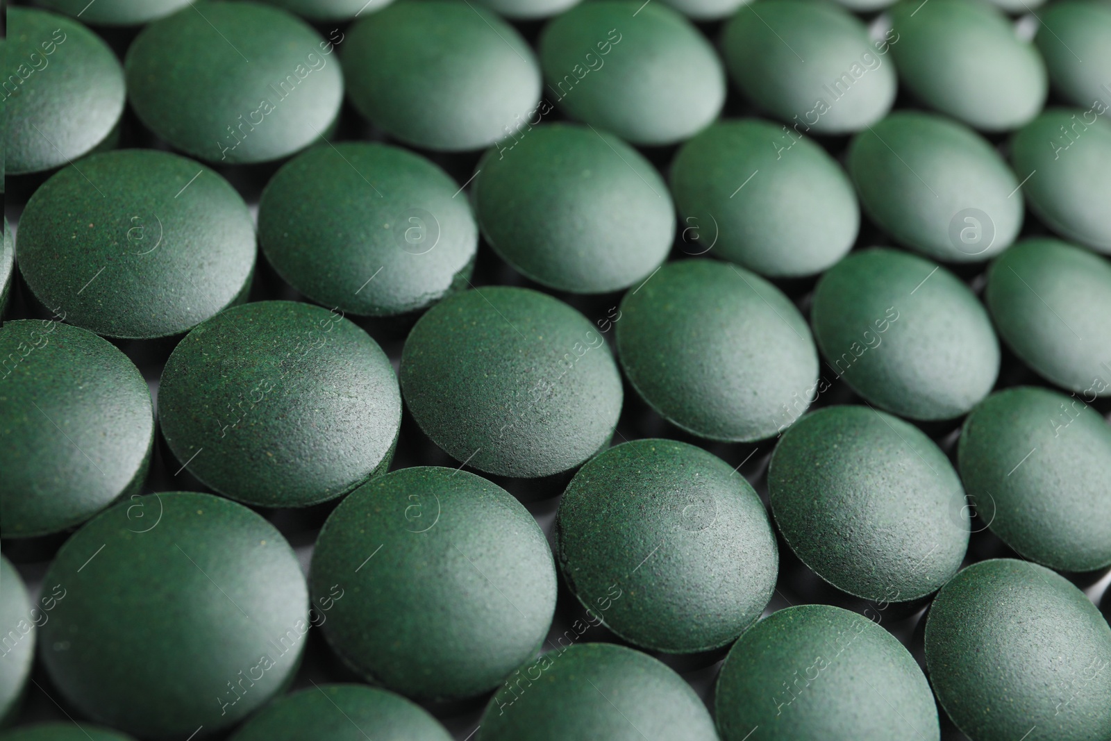 Photo of Closeup view of spirulina tablets on table