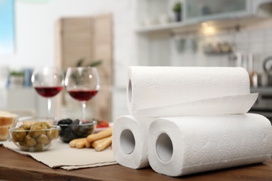 Photo of Rolls of paper towels on table in kitchen, space for text