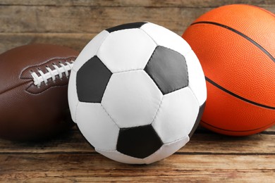 Set of different sport balls on wooden table, closeup