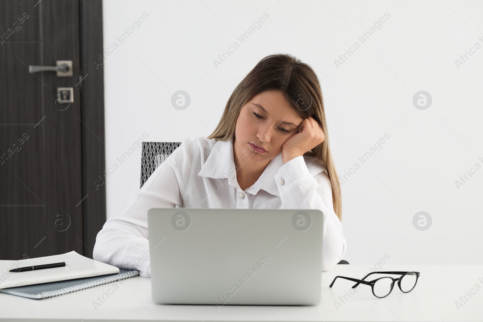 Photo of Sleepy young woman at workplace in office