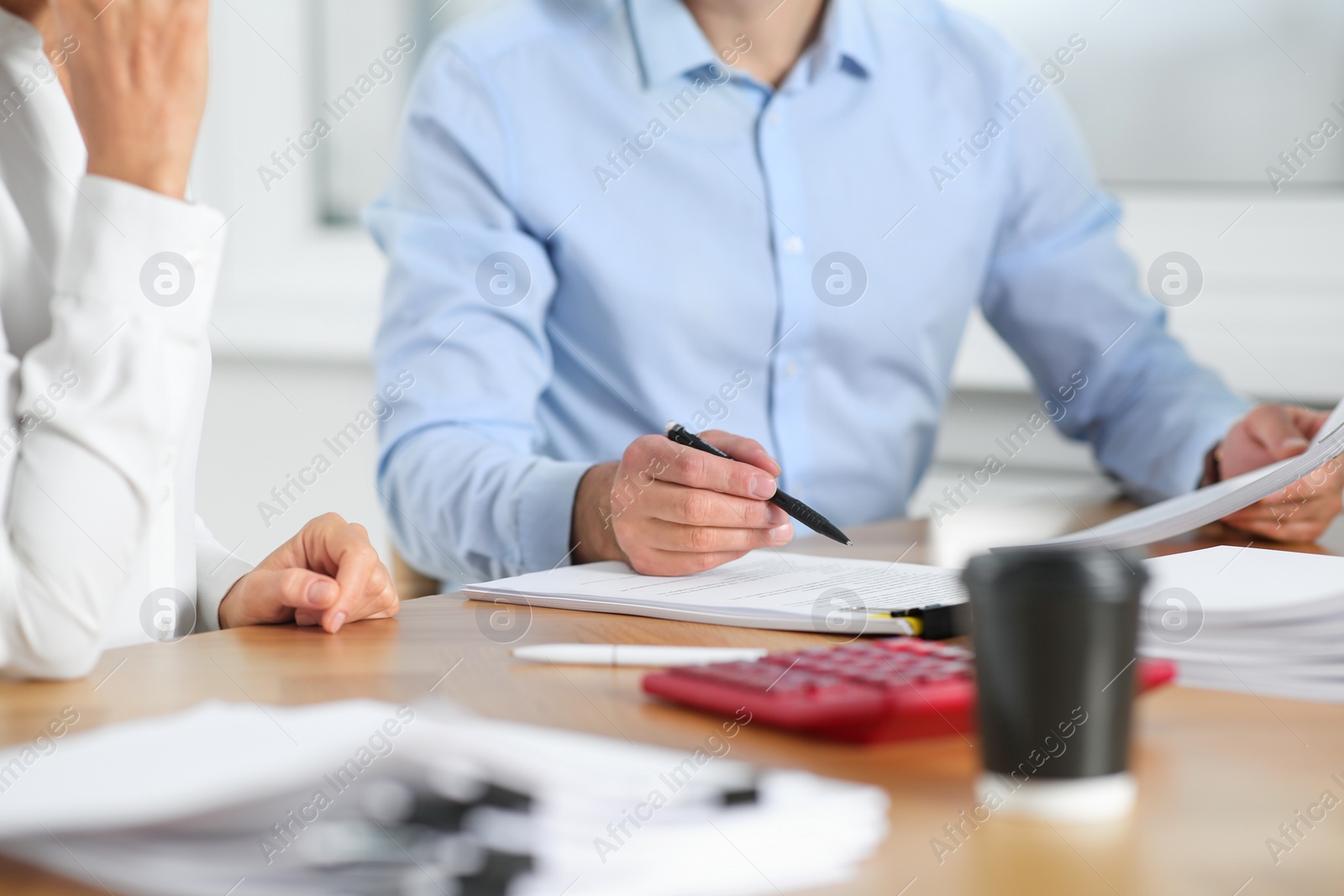 Photo of Businesspeople working with documents at table in office, closeup