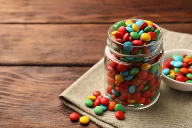 Tasty colorful candies on wooden table, space for text