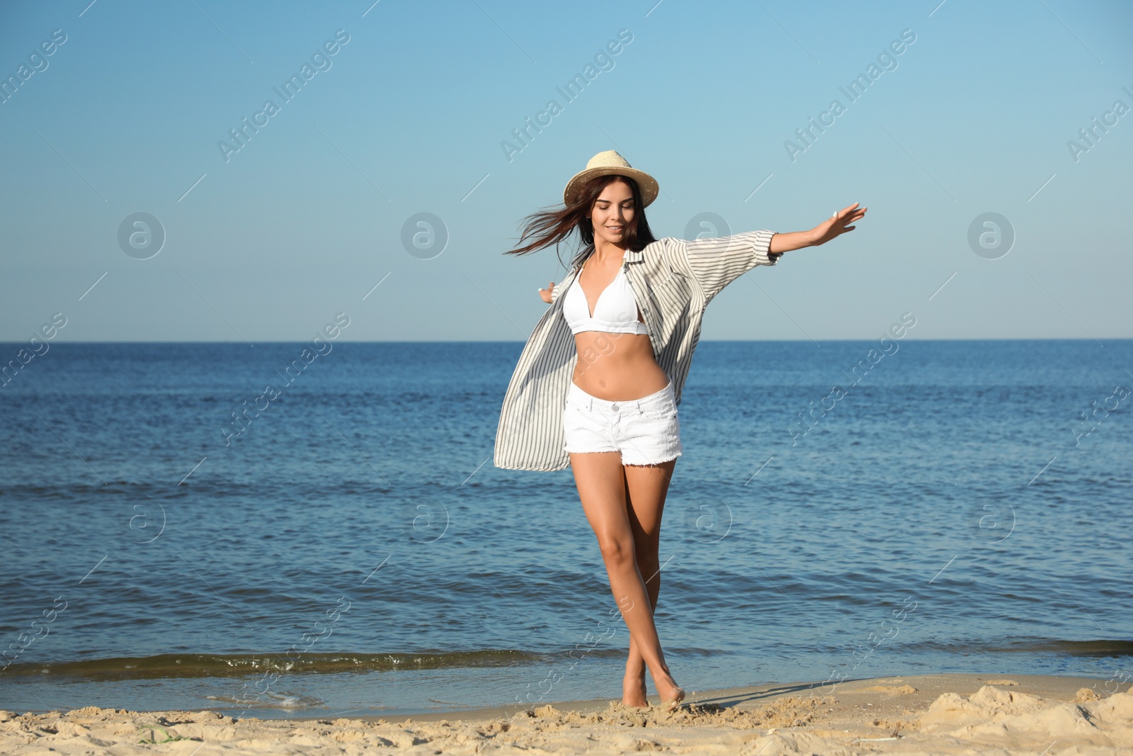 Photo of Beautiful young woman in hat on beach