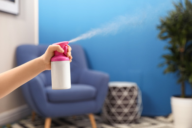 Photo of Woman spraying air freshener at home, closeup