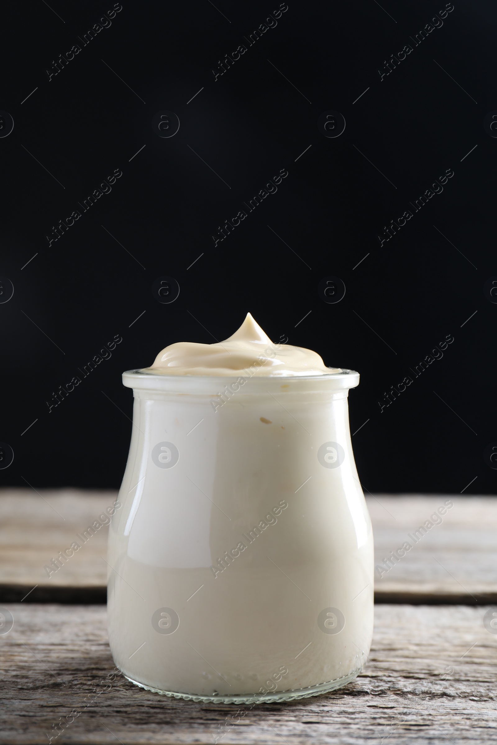 Photo of Fresh mayonnaise sauce in glass jar on wooden table