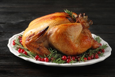 Platter of cooked turkey with garnish on wooden table