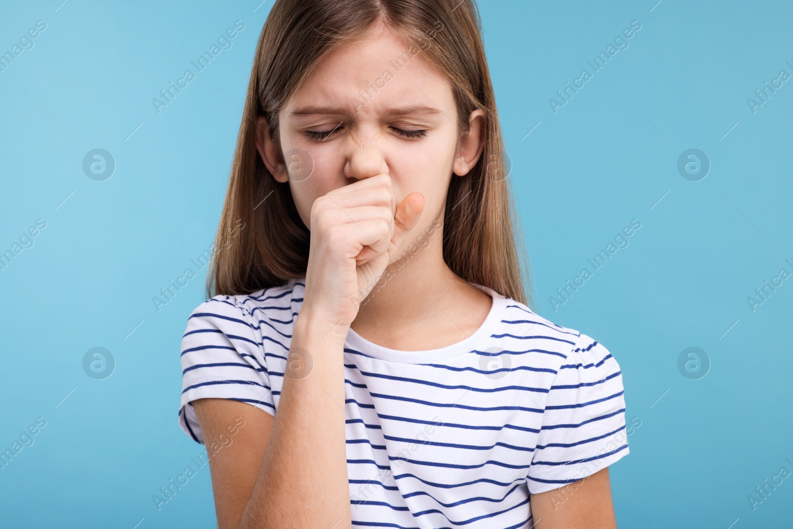 Photo of Sick girl coughing on light blue background