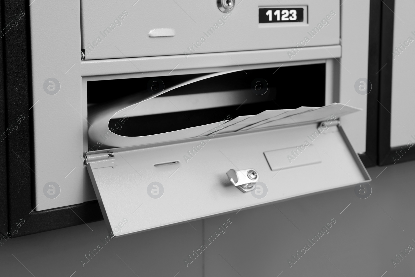 Photo of Open grey metal mailbox with envelopes indoors