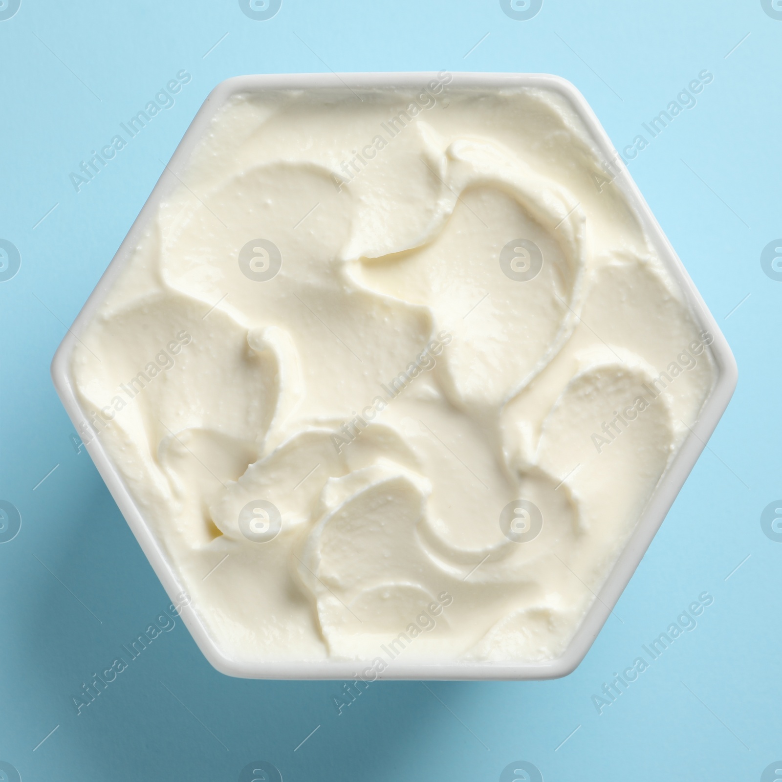 Photo of Bowl of tasty cream cheese on color background, top view