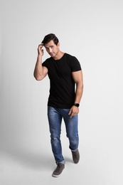 Full length portrait of handsome young man in casual clothes on grey background