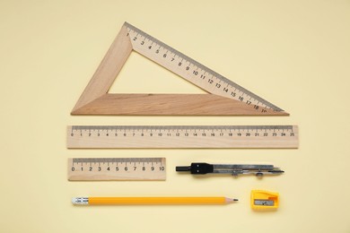 Photo of Flat lay composition with different rulers and compass on yellow background