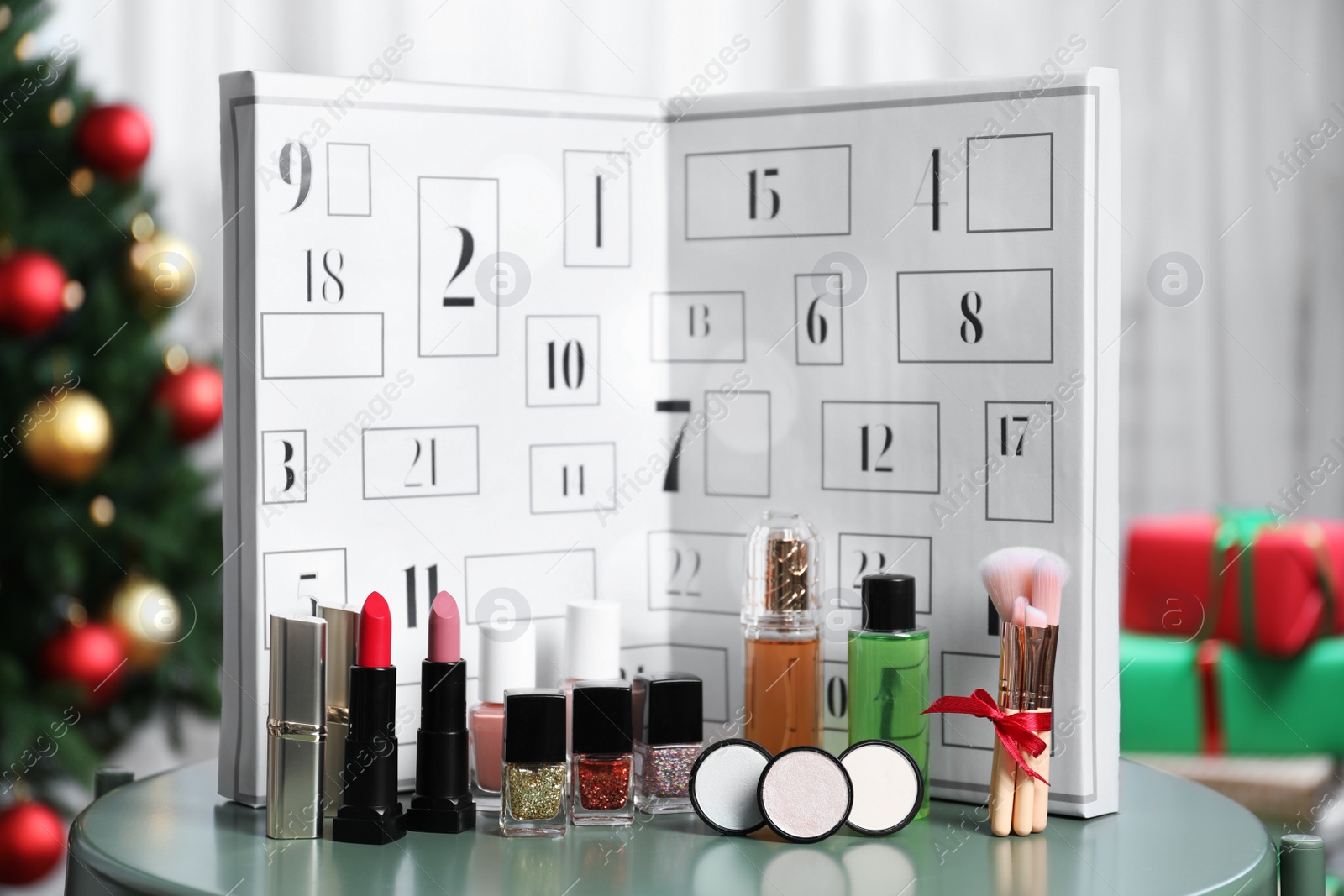 Christmas advent calendar with perfume and makeup products on table Photo of Christmas advent calendar with perfume and makeup products on table