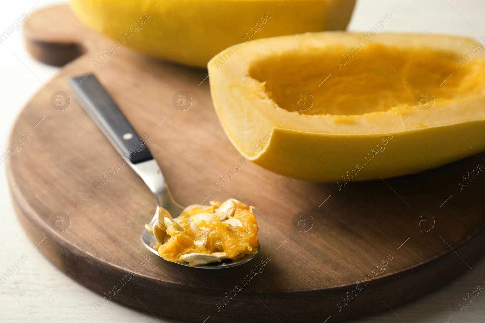 Photo of Cut spaghetti squash and spoon on wooden table