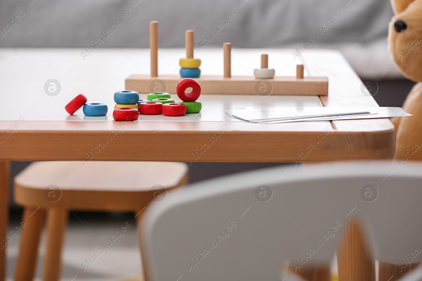 Photo of Stacking and counting game on table indoors. Educational toy for motor skills development