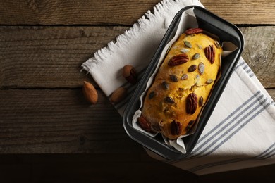 Photo of Delicious pumpkin bread with pecan nuts on wooden table, flat lay. Space for text