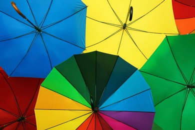 Many stylish colorful umbrellas as background, closeup