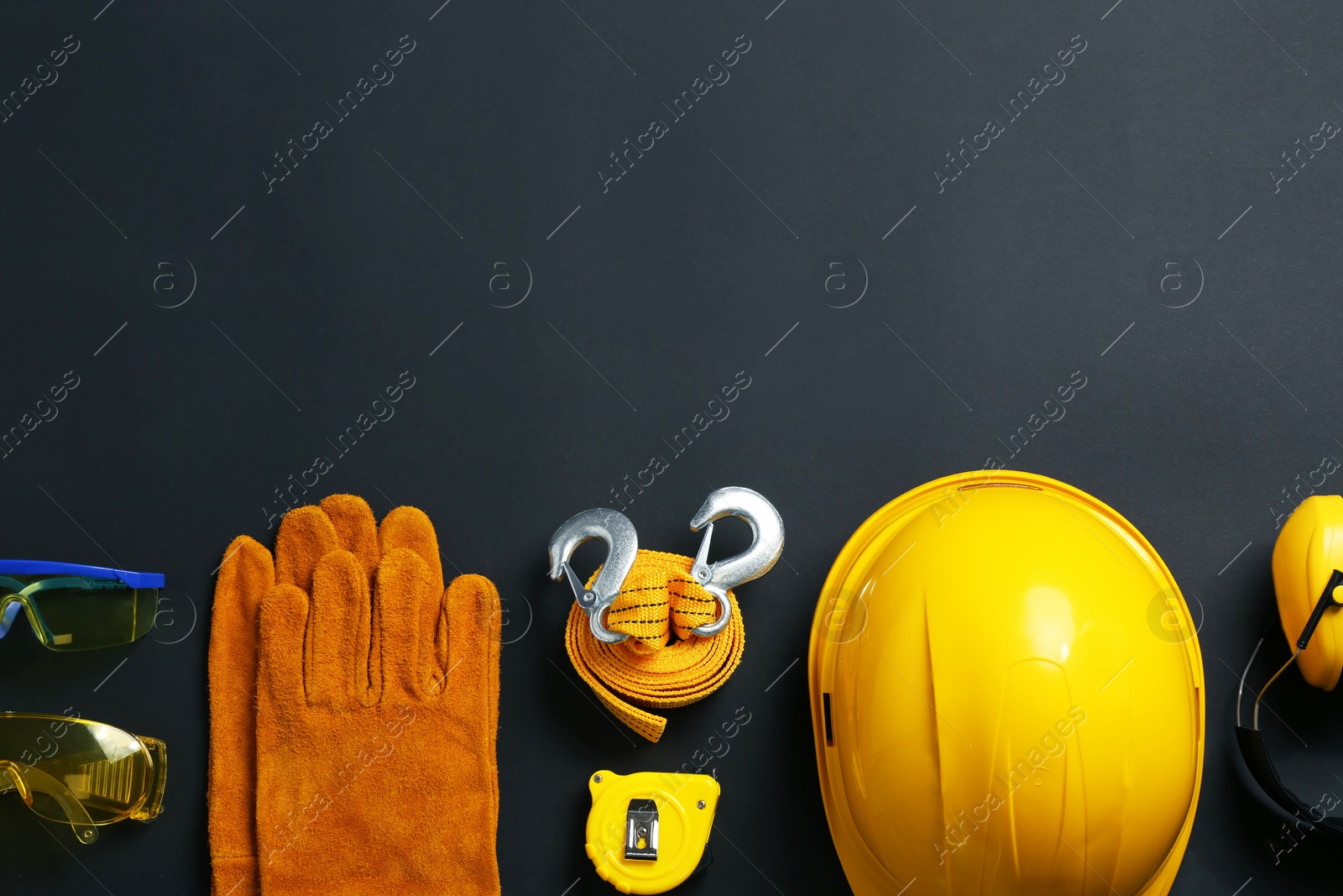 Photo of Flat lay composition with safety equipment and space for text on black background