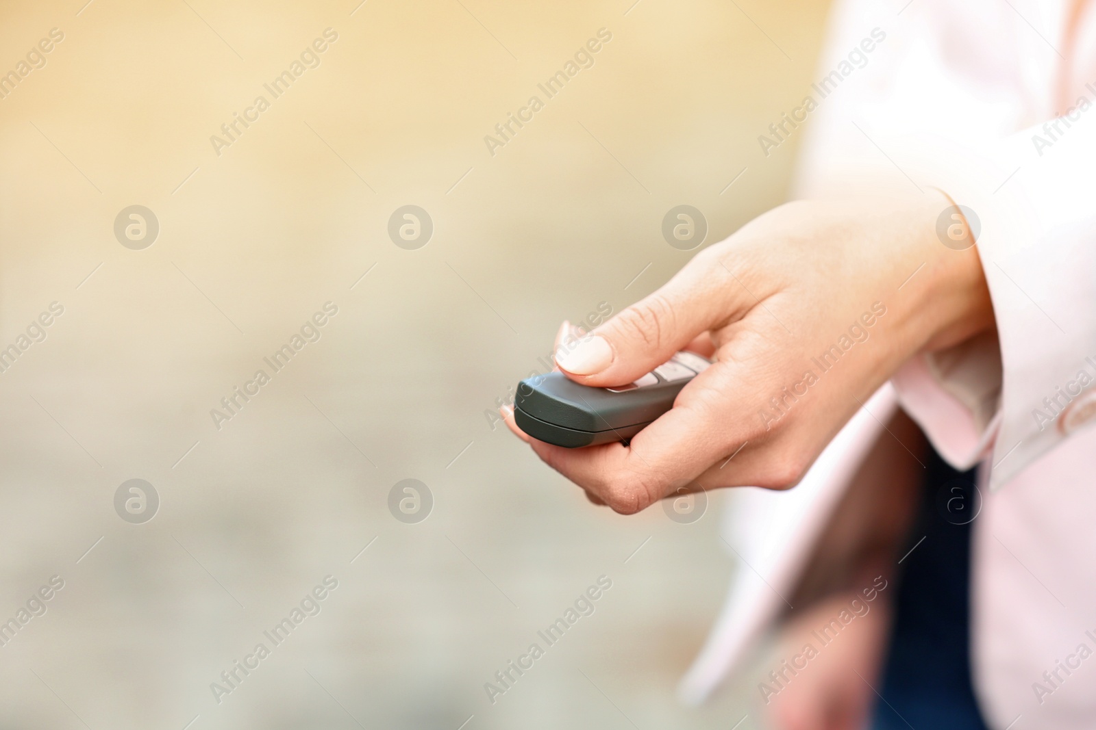 Photo of Closeup view of woman opening car door with remote key. Space for text