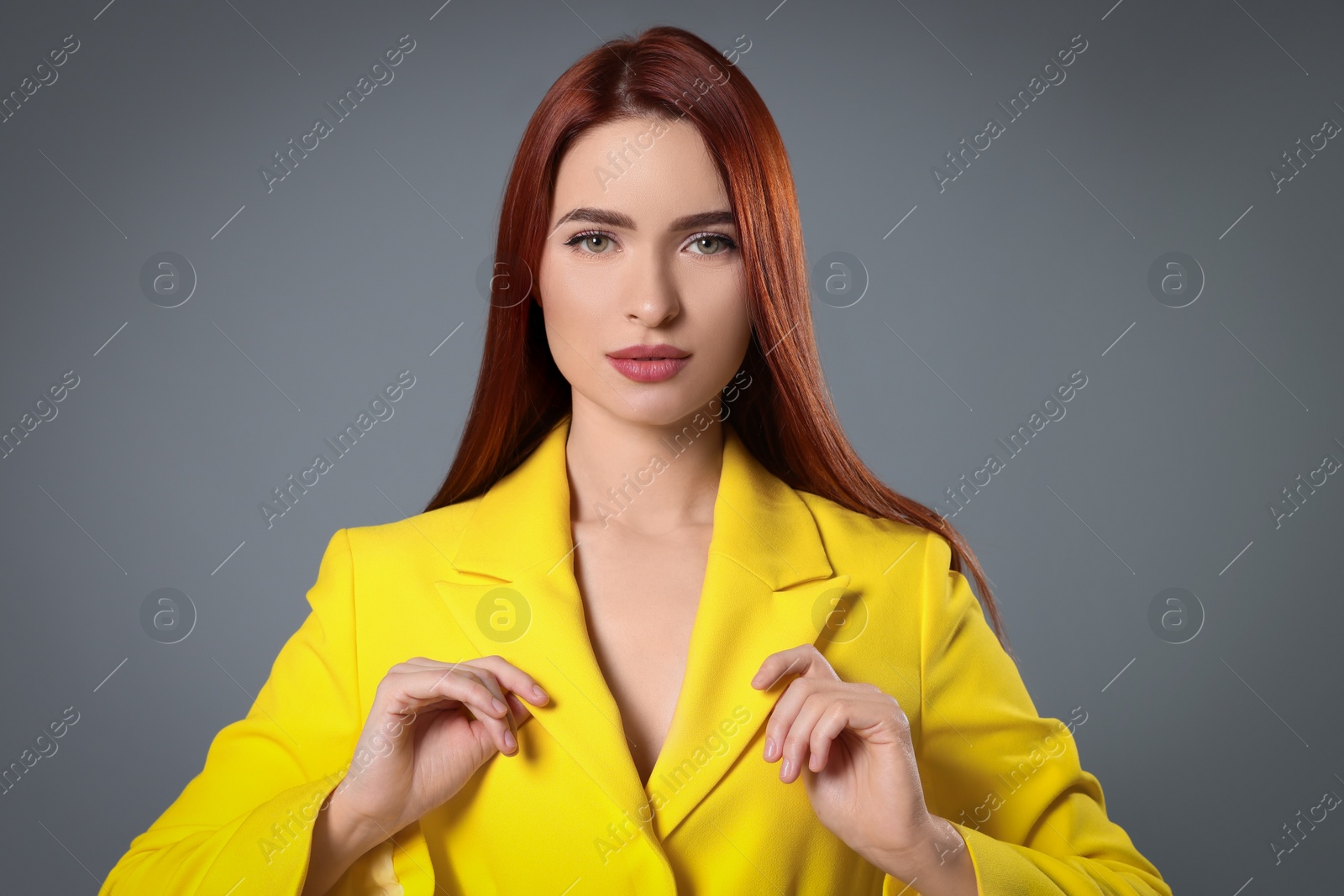 Photo of Beautiful woman with red dyed hair on light gray background